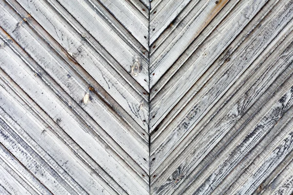 The walls are made of wooden planks with traces of old paint. The texture of the wooden boards are arranged asymmetrically in the background with a copy of the space