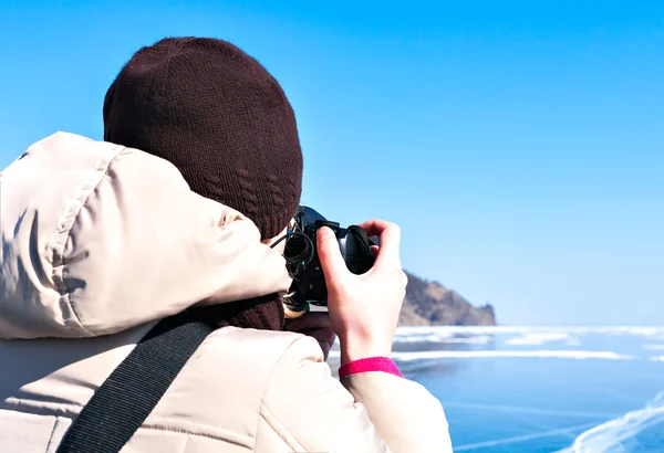 Photographer in winter. Ice on Lake Baikal.