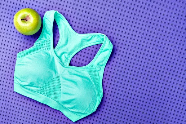 Yoga mat. Green apple. Purple background. Fitness tank top,