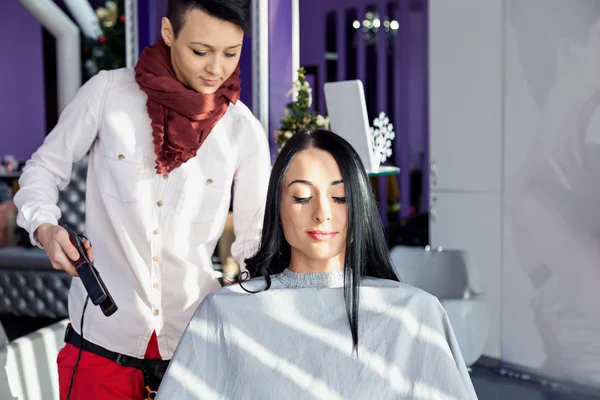 Girl with long black hair in a barber chair..