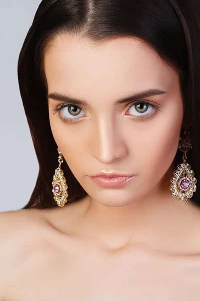 Girl with clean skin and beautiful face. Model in jewelry