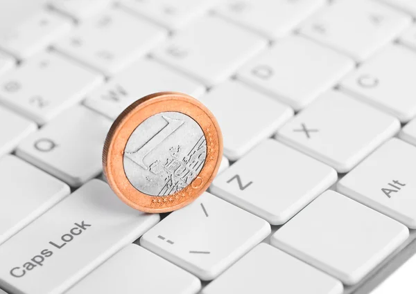 Coin one euro is on the keyboard
