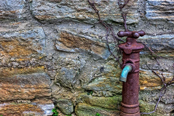 Old Rusty Water Faucet on side of building