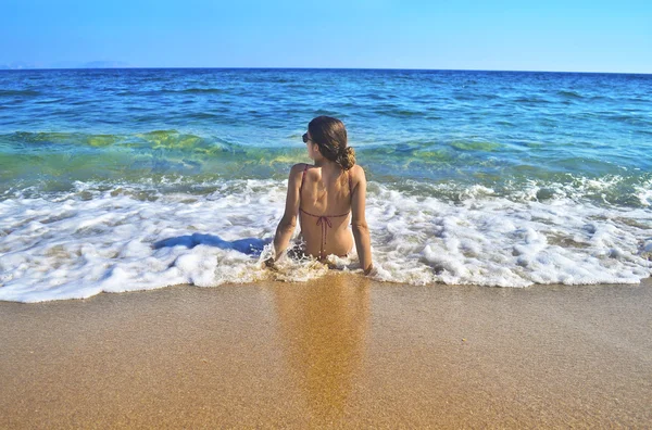 Girl sitting at a greek beach