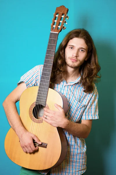 Haired man playing classical acoustic guitar