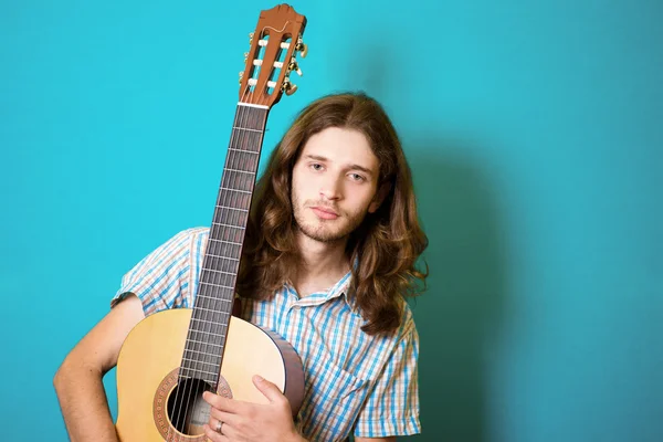 Haired man playing classical acoustic guitar