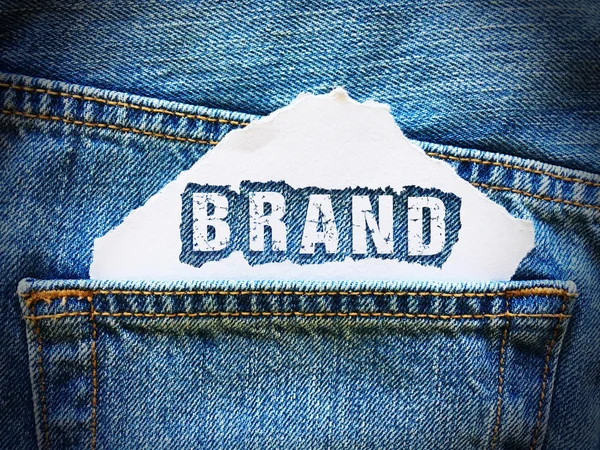 Brand word on white paper in the pocket of blue denim jeans