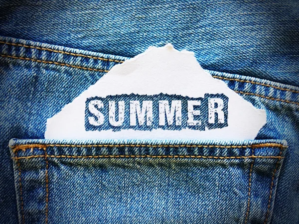 Summer word on white paper in the pocket of blue denim jeans