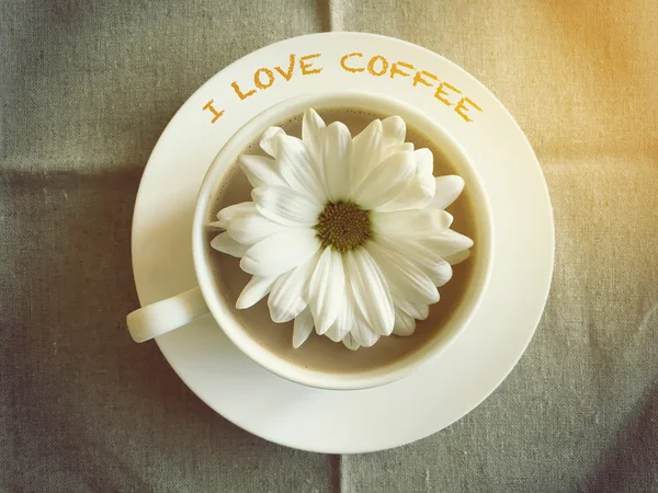 Coffee cup on table with white daisy - I love coffee word vintag