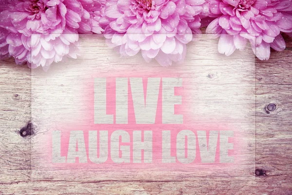 Pink flowers on wooden with word live laugh love