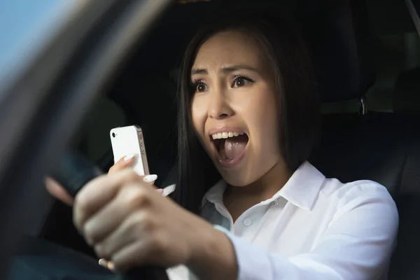 Young pretty scared woman in the car