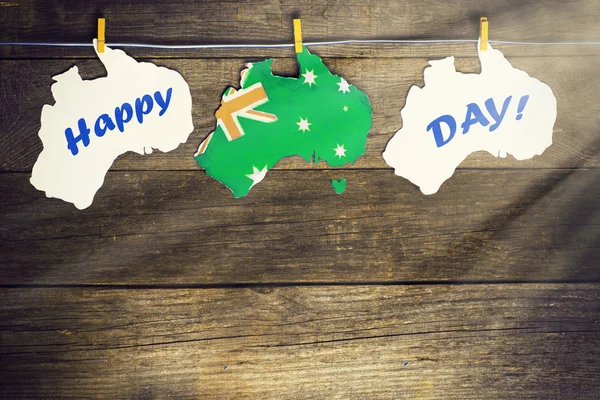 Celebrate  holiday on January 26. Concept - Happy Australia Day Map of Australia with  flag in unofficial popular green and gold colours hanging pegs on a line. toned image, sunlight effect