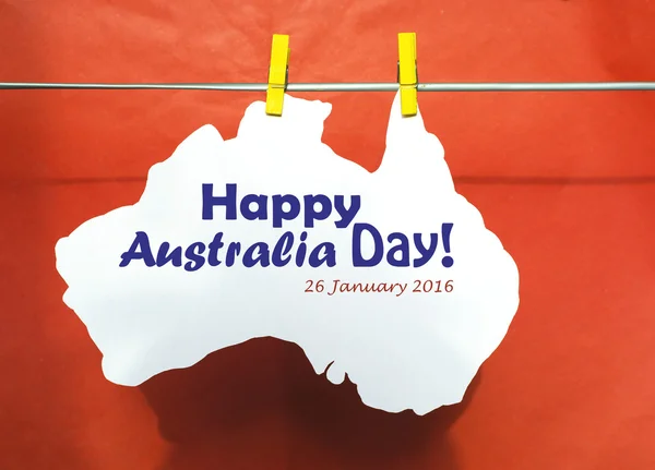 Celebrate Australia Day holiday on January 26 2016 with a Happy Australia Day message greeting written across white Australian maps (red heart) and flag hanging pegs on blue.