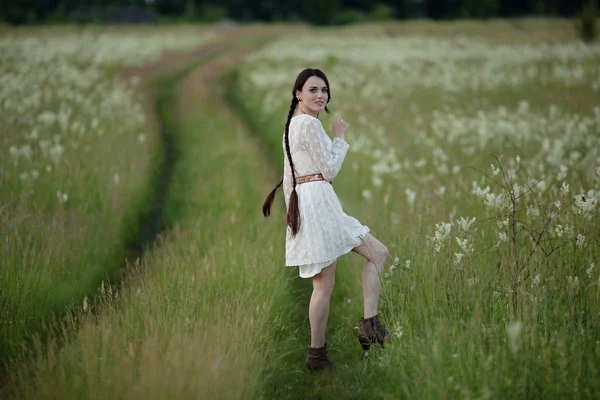 Young girl with long dark hair running joyfully in the summer field.