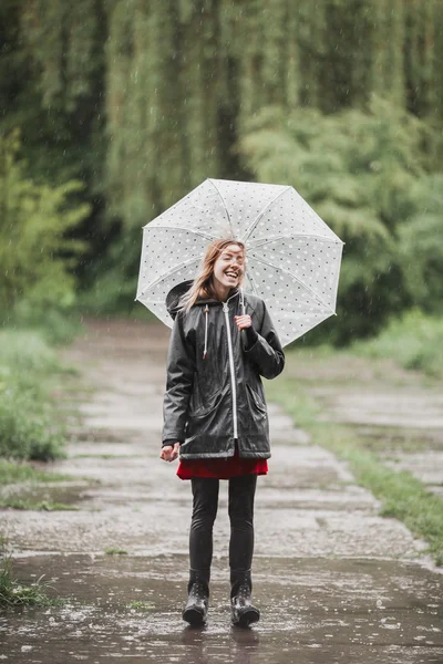 Young girl having fun in the rain. Joyful rain concept