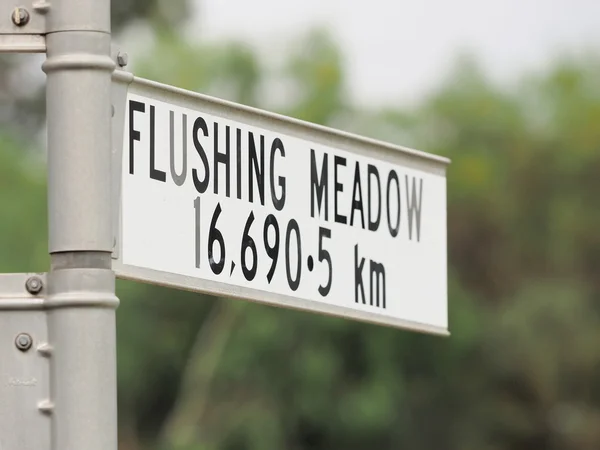 Sign stating distance from sign to Flushing Meadow in New York