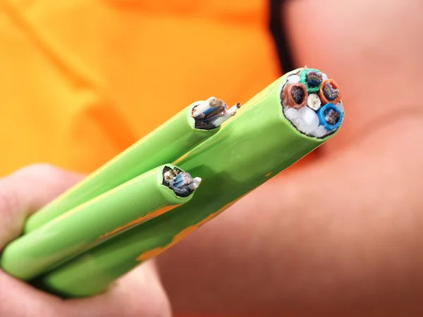 Installer holding green Nylon jacketed fiber optic cables with 576, 144 and 72 fibres