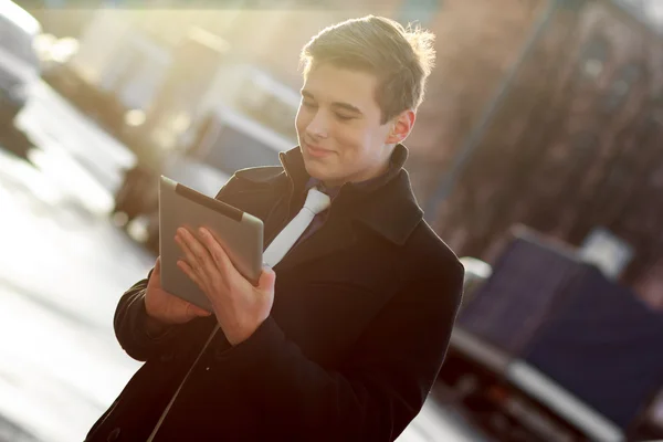 Business man in coat using tablet