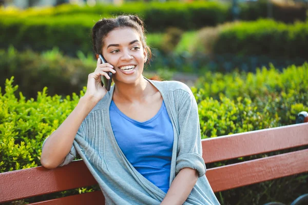 Beautiful cheerful dark skinned girl talked on phone