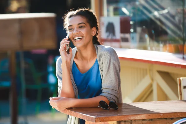 Beautiful cheerful dark skinned girl talked on phone