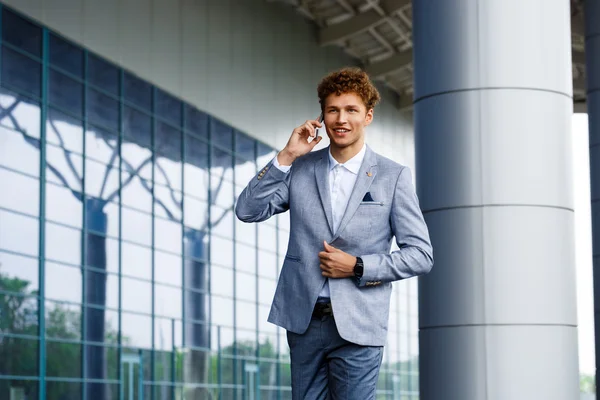 Picture of handsome young redhaired businessman  talking on phone