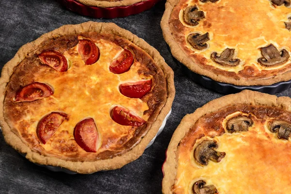 Picture of vegetable pies with tomatoes and mushrooms on grey background