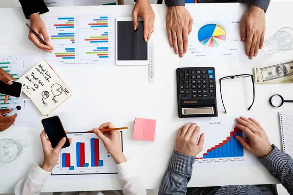 Picture of businessmens hands on white table with documents and drafts