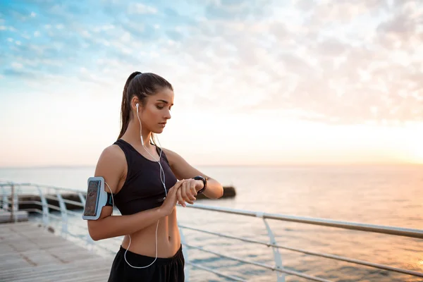 Sportive girl looking at watch