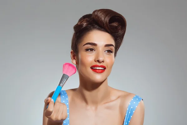 Pin-up woman holding make-up brush
