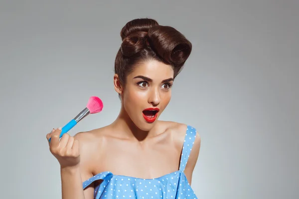 Pin-up woman holding make-up brush