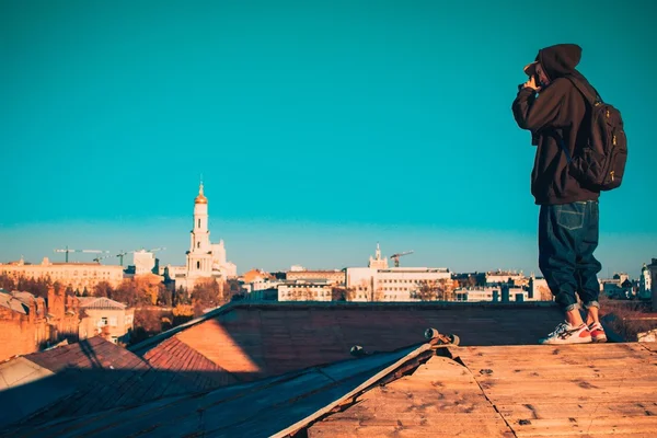 Guy taking photo of buildings on roof