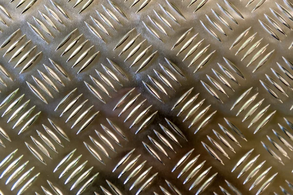 Metallic plate with a grid imposed pattern for gripping