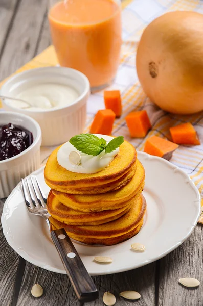 Pumpkin pancakes with pumpkin smoothie, cream fresh and jam.