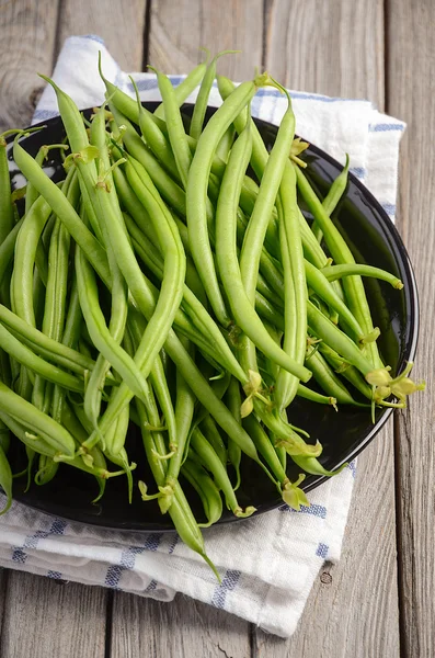 French beans on wooden background