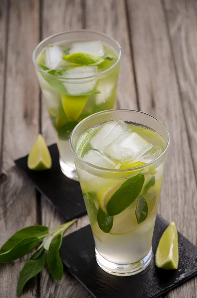 Pear lemonade with lime and sage on wooden background