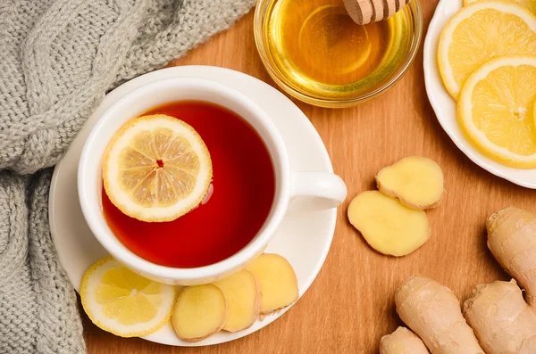 Black tea with lemon, ginger and honey on the wooden table.