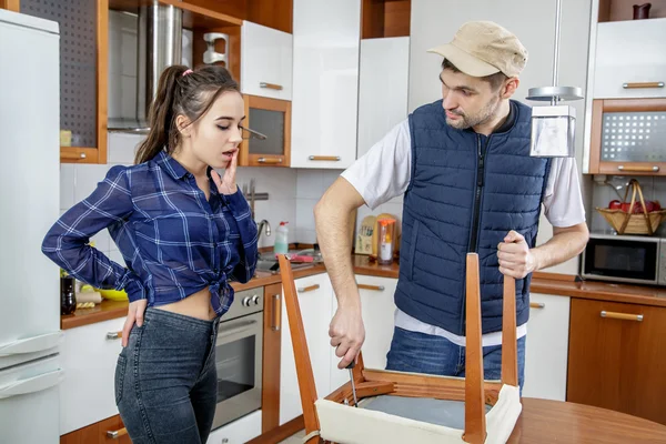 Handyman repairing furniture in the kitchen.