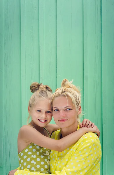 Two blondes Mom and daughter smiling, hugging