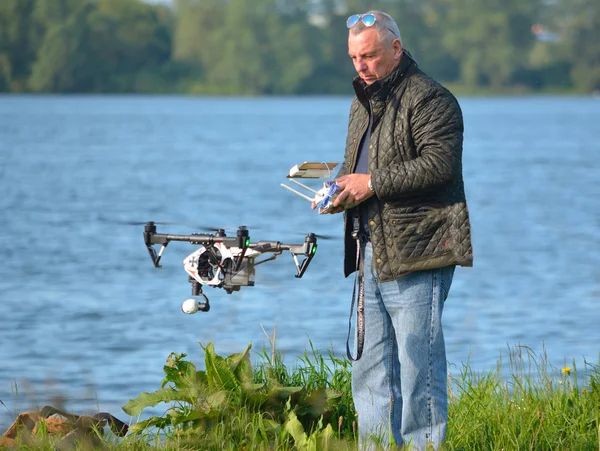 Man flying Drone, Drone in picture, water in background.
