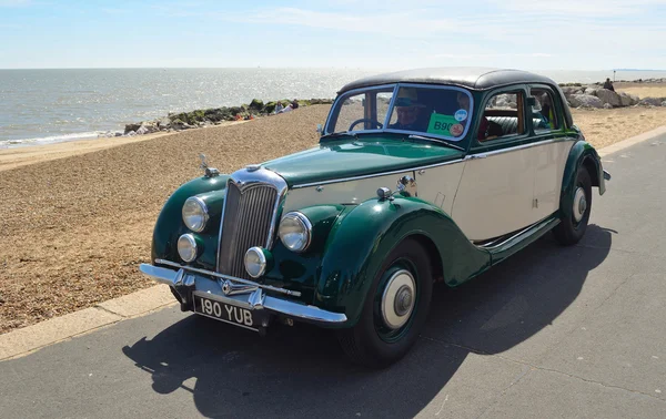 Vintage Green and Cream Riley Motor Car parked on seafront promenade.