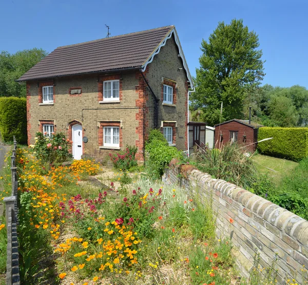 English cottage with colourful cottage garden and wall.