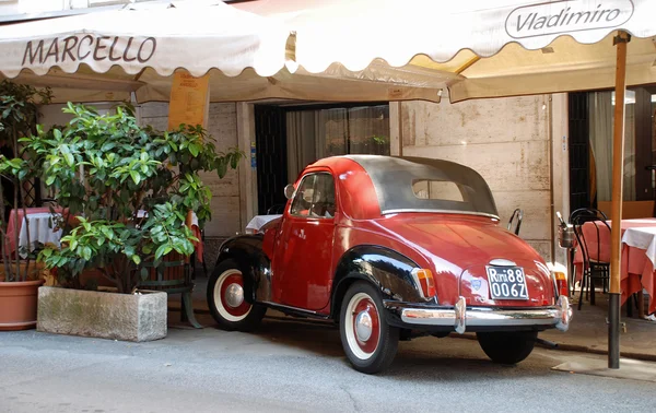 Classic car parked outside restaurant in Rome.