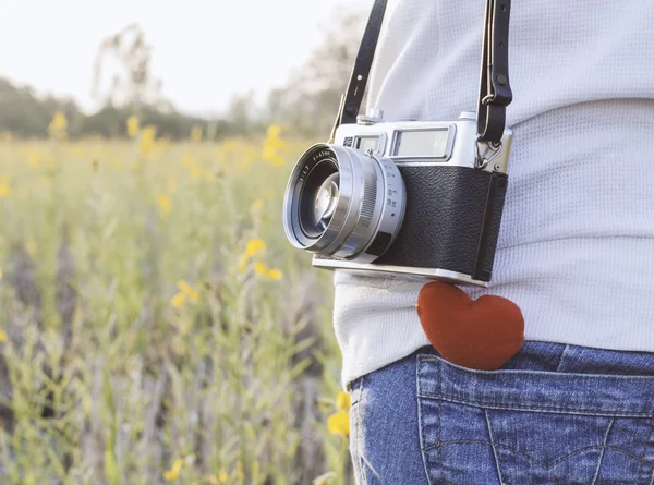 Young  woman  photographer with retro camera and red Heart in fl