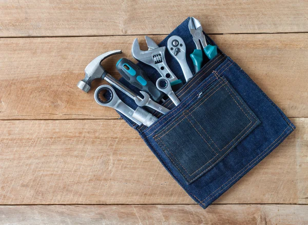 Tool belt with tools on wooden board background