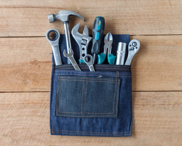 Tool belt with tools on wooden board background