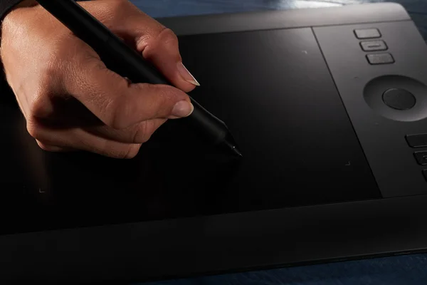 Hand draws a black professional graphics tablet