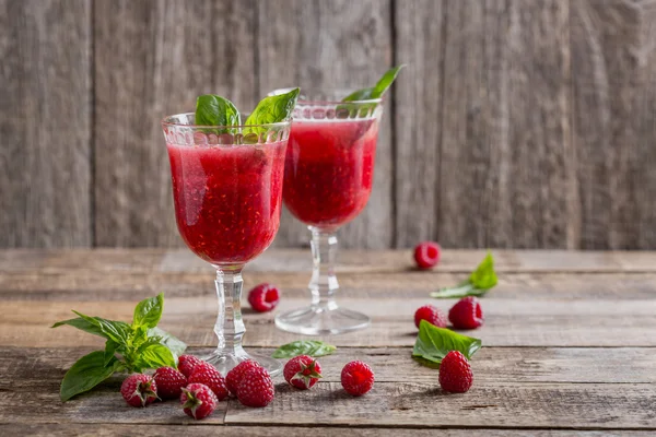 Raspberry drink-cocktail with Basil. Rustic style, wooden background, feed in the glass.