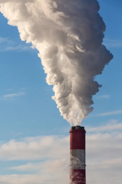 White smoke clouds from a high heating plant chimney