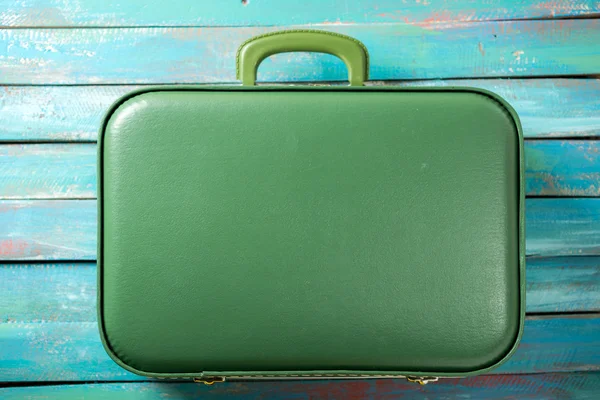 Full suitcase on a distressed blue background