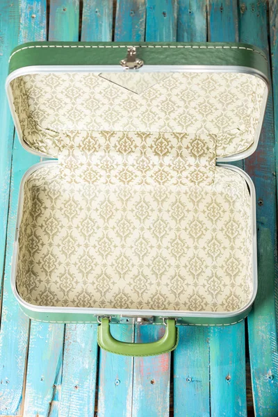 Full suitcase on a distressed blue background